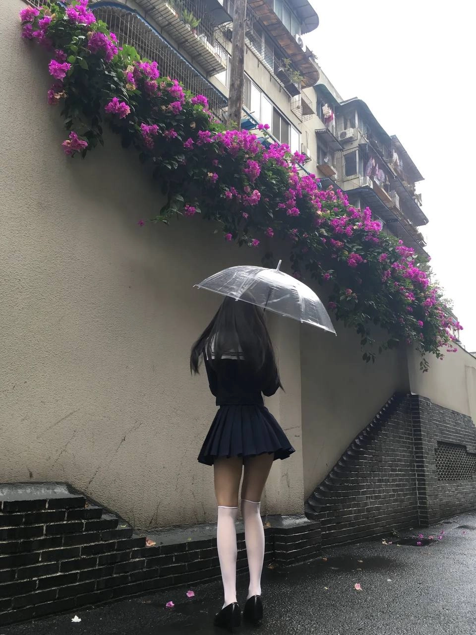 一位穿着蓝色裙子的女人站在一辆黄色的自行车旁边。