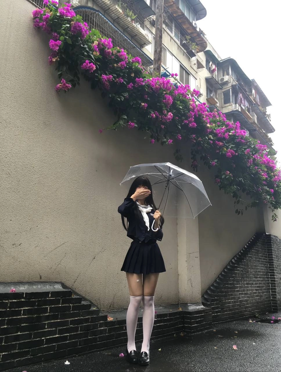 一位穿着蓝色裙子的女人站在一辆黄色的自行车旁边。