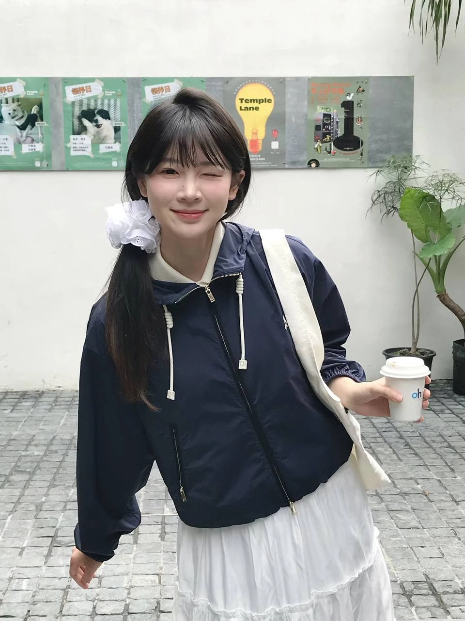 穿着白色衬衫和蓝色条纹的女人坐在一张桌子上。