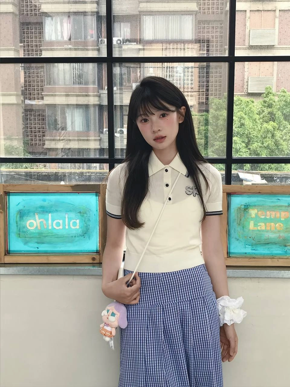 穿着白色衬衫和蓝色条纹的女人坐在一张桌子上。