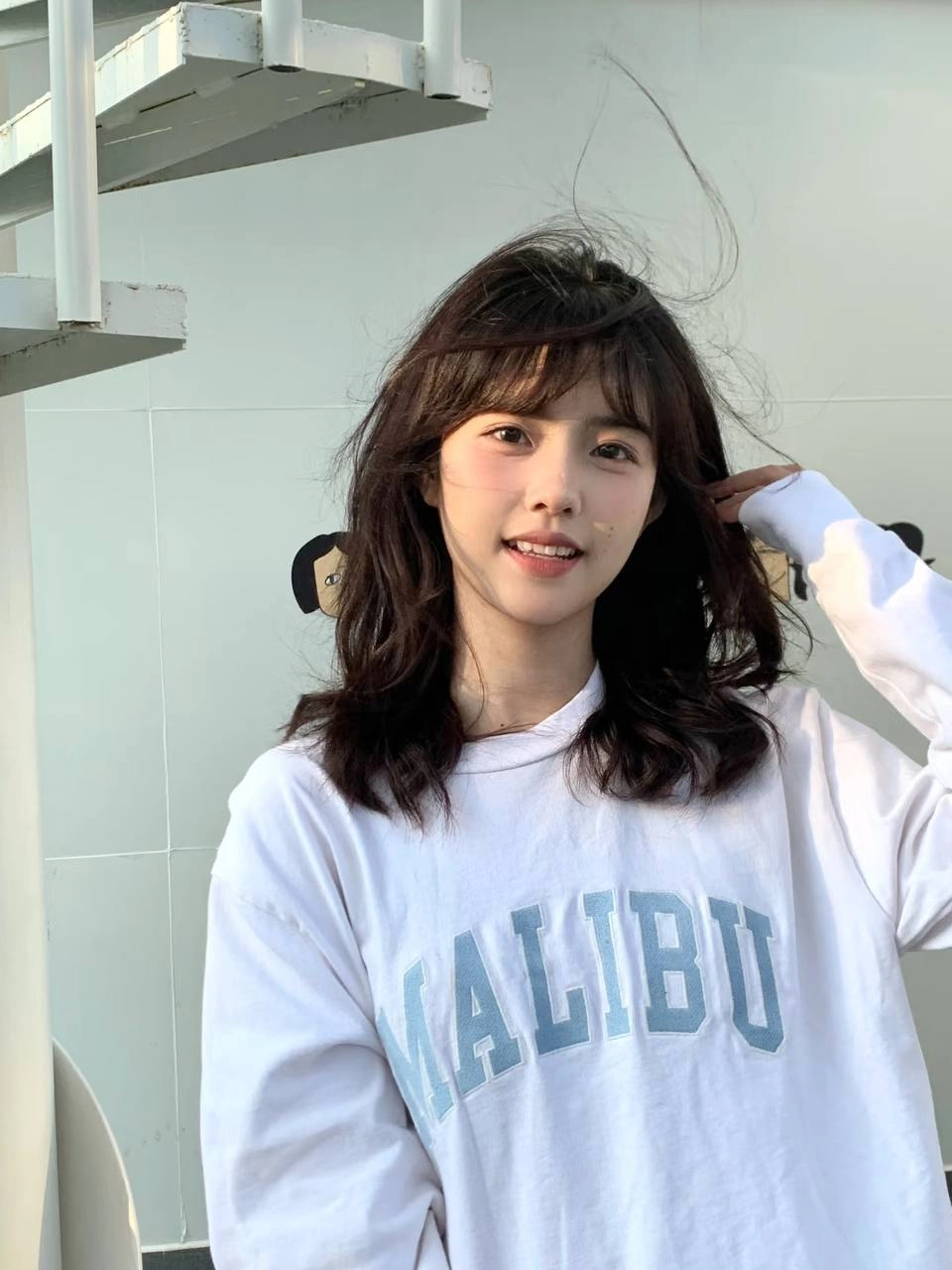 女人穿着一件白色衬衫,戴着一件白色衬衫。