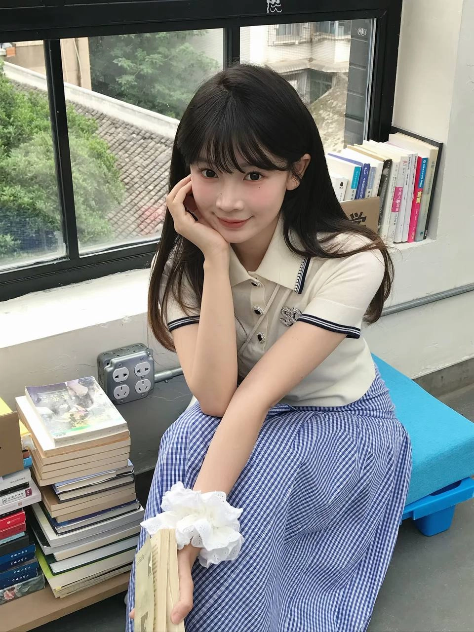 穿着白色衬衫和蓝色条纹的女人坐在一张桌子上。