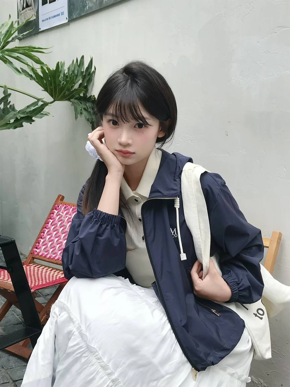 穿着白色衬衫和蓝色条纹的女人坐在一张桌子上。