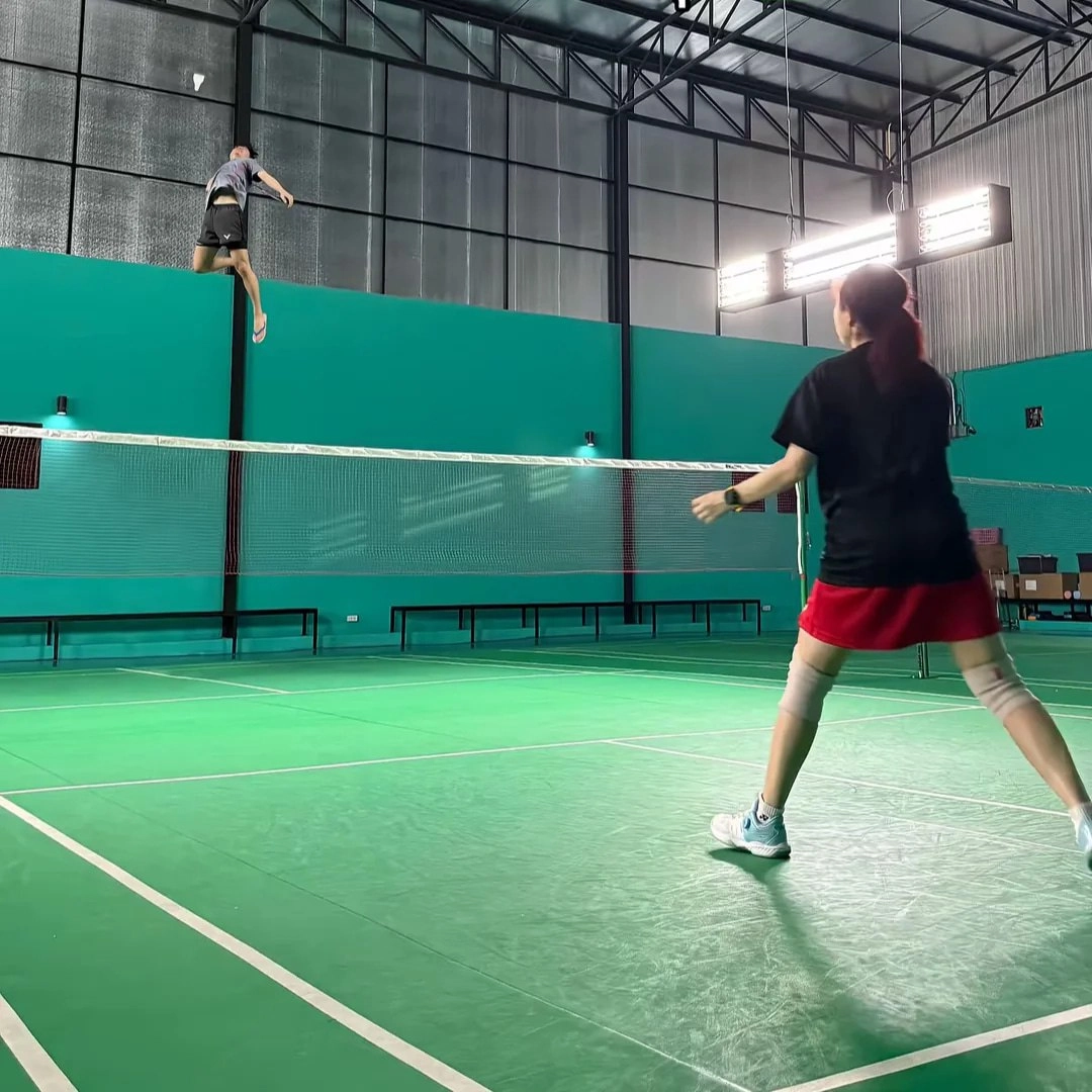 女人在打网球,跳进空中打球。