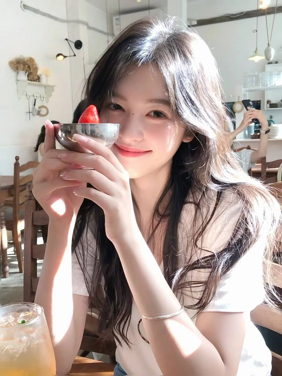 女人拿着一个碗,里面有草莓。