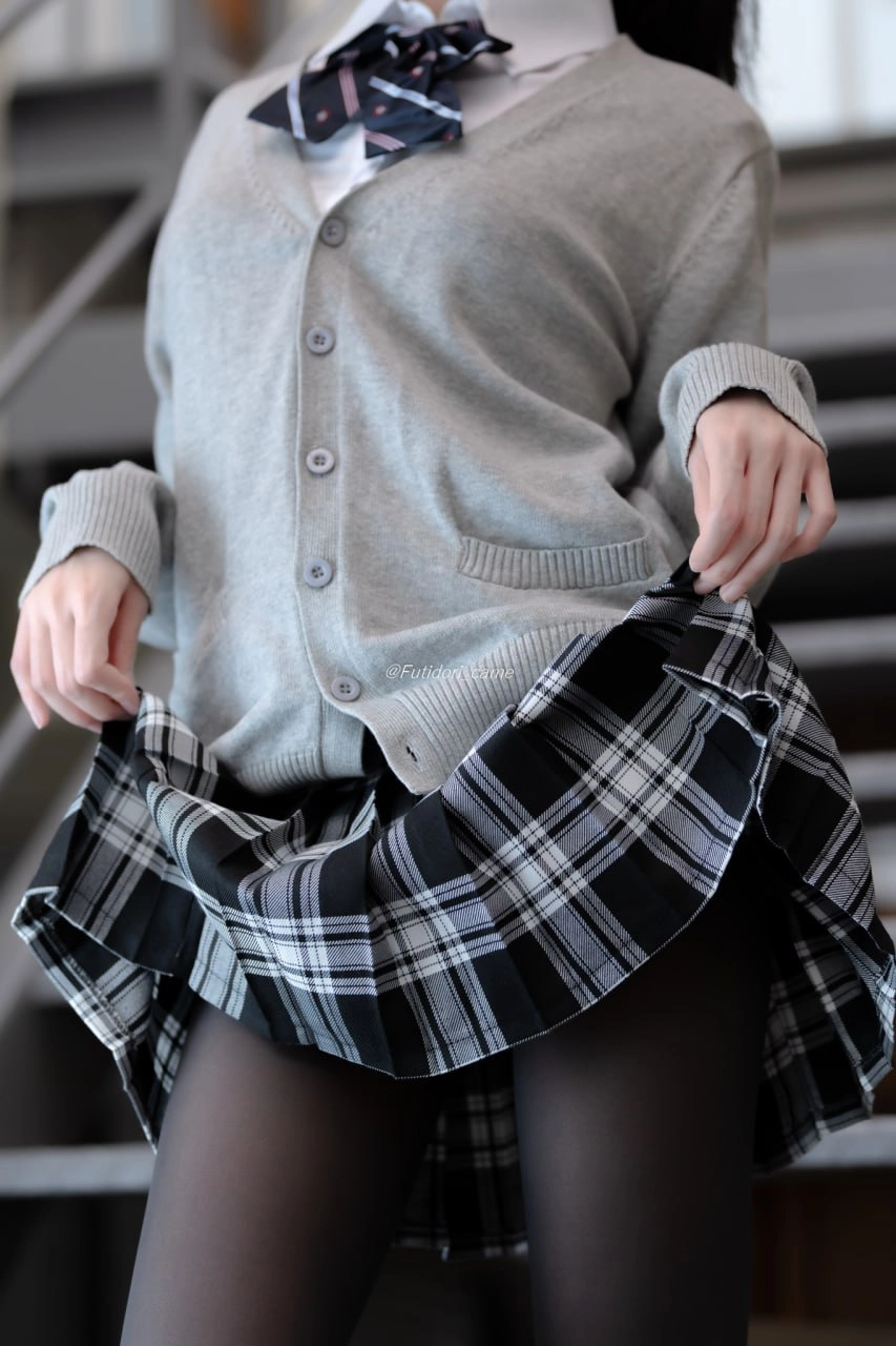 穿着灰色衬衫和黑白裙子的女人。