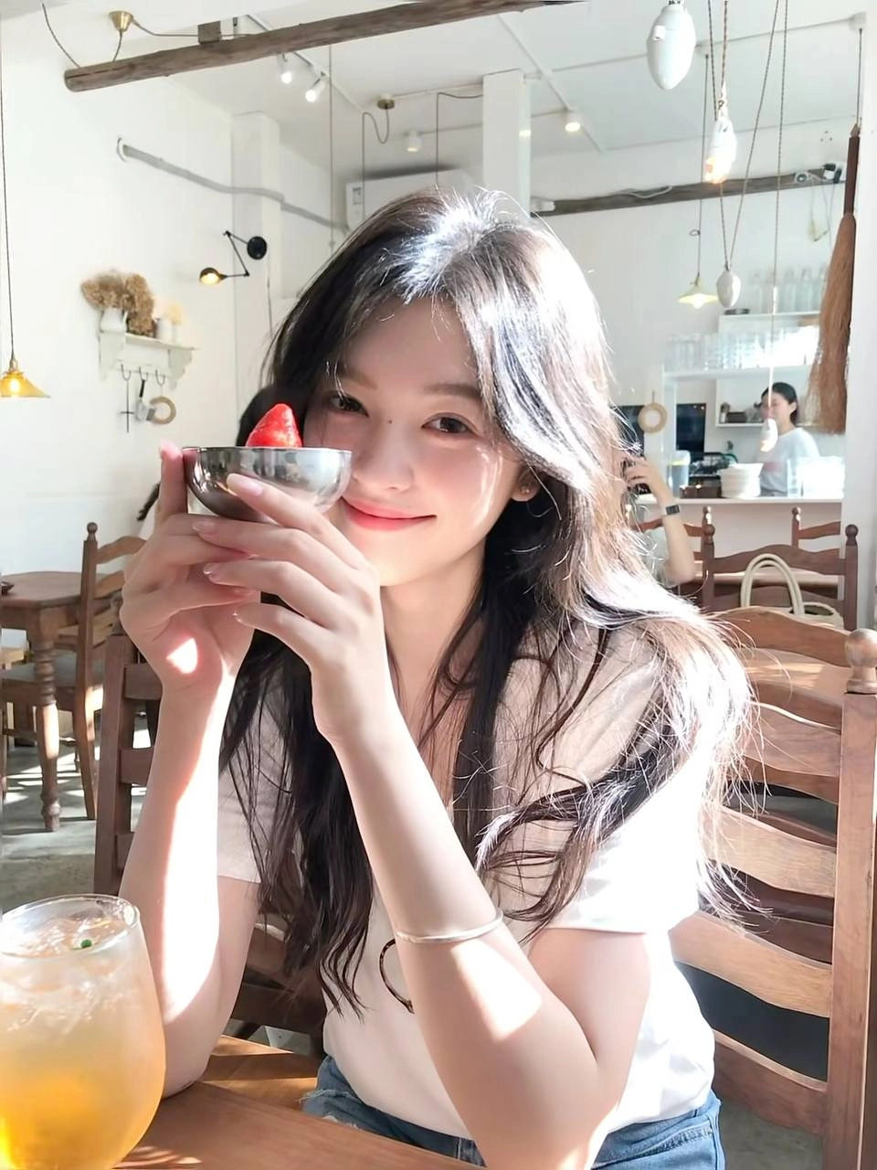 女人拿着一个碗,里面有草莓。