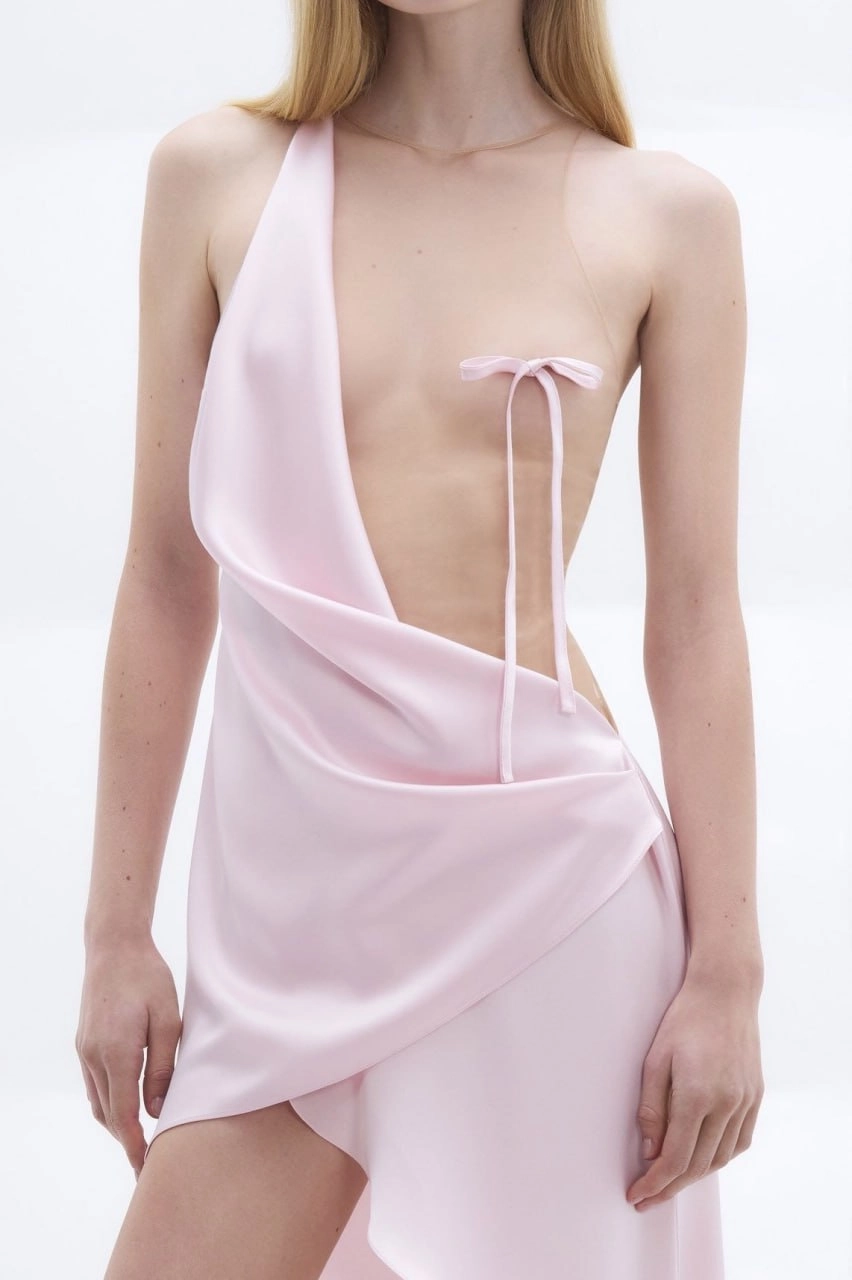 女人穿着一个粉红色的裙子与一个弓。