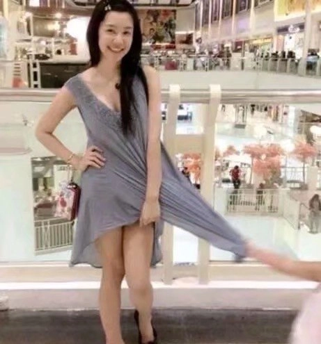 穿着灰色衣服的女人为一张照片而立场。