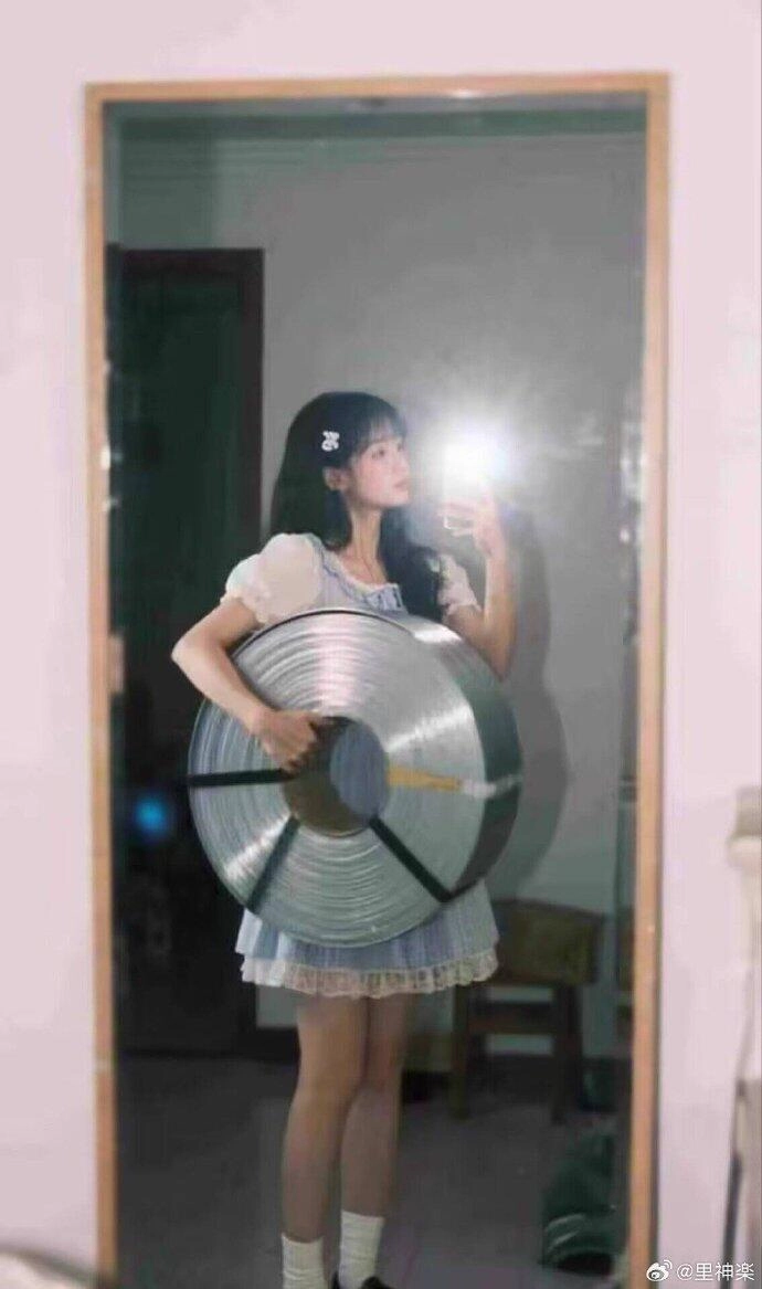 小女孩抱着一块金属。