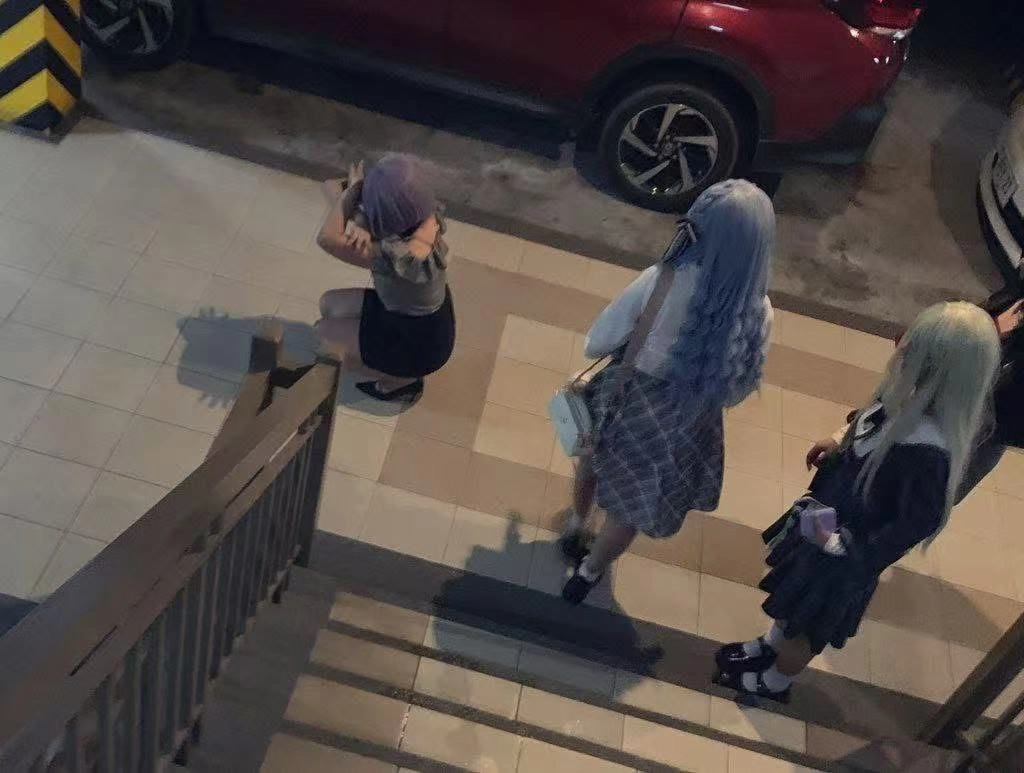 三个女孩站在楼梯上。