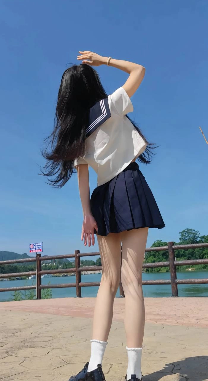 长头发和蓝色和白色衬衫的女人举起她的手臂。