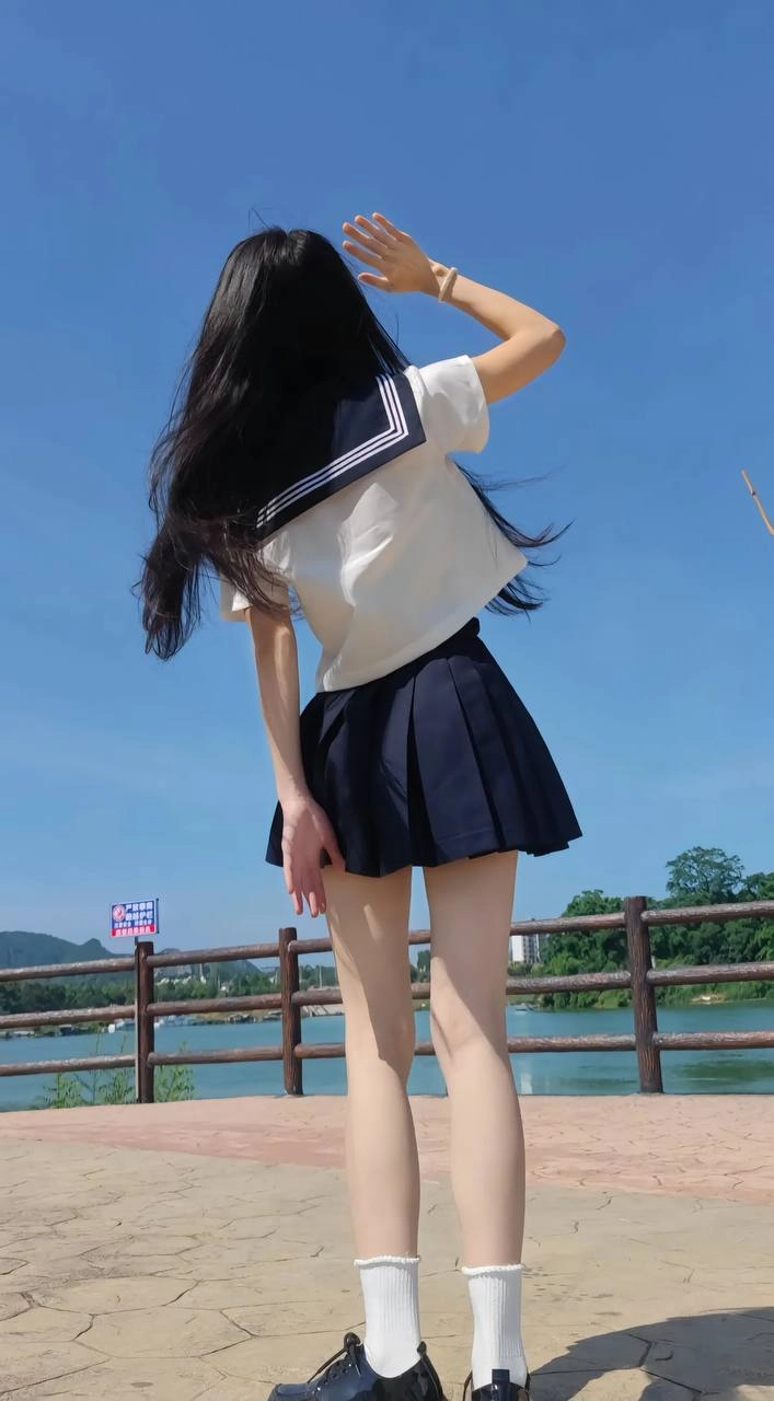 长头发和蓝色和白色衬衫的女人举起她的手臂。