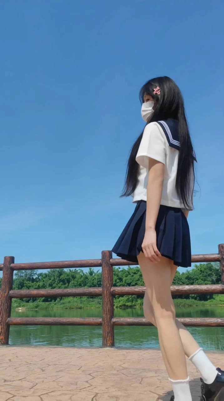 长头发和蓝色和白色衬衫的女人举起她的手臂。