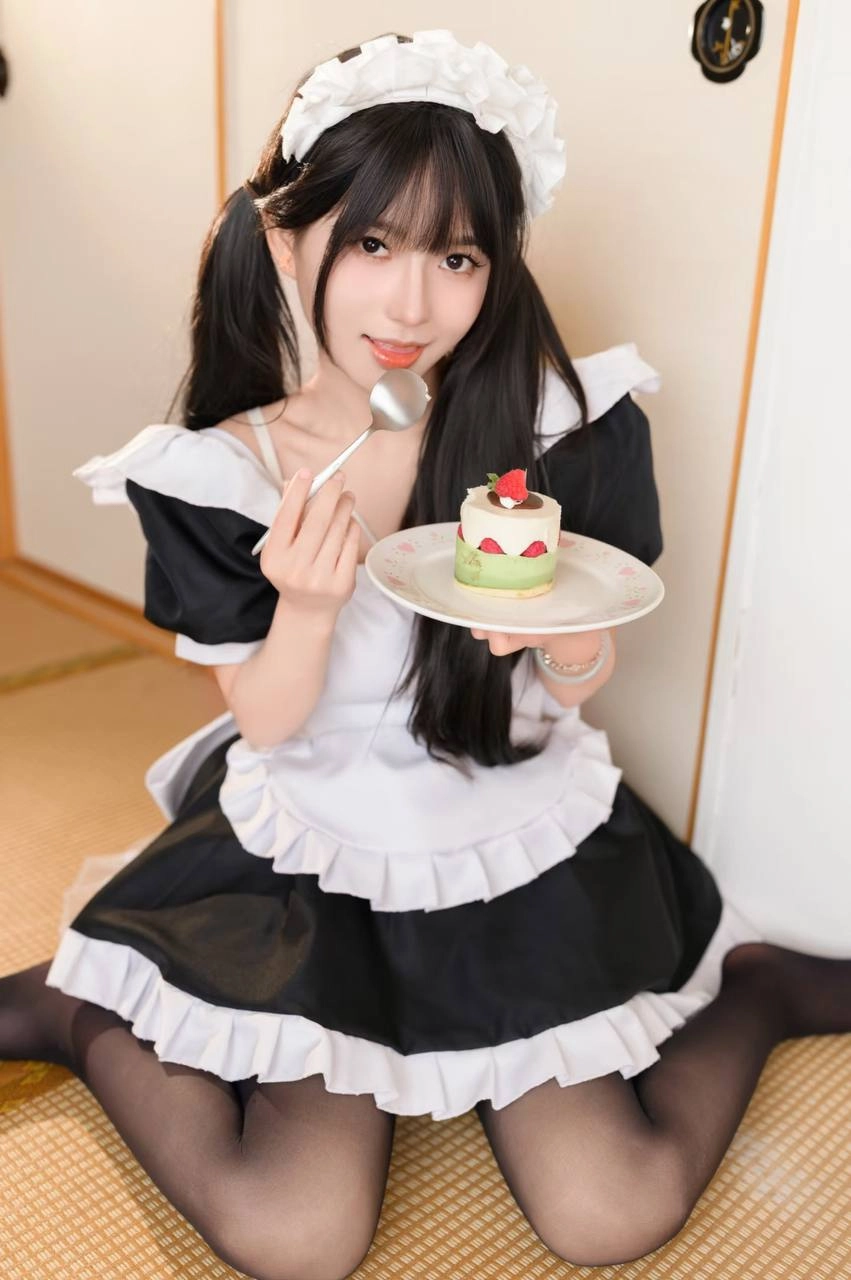 穿着女仆服的女孩吃了一块蛋糕。