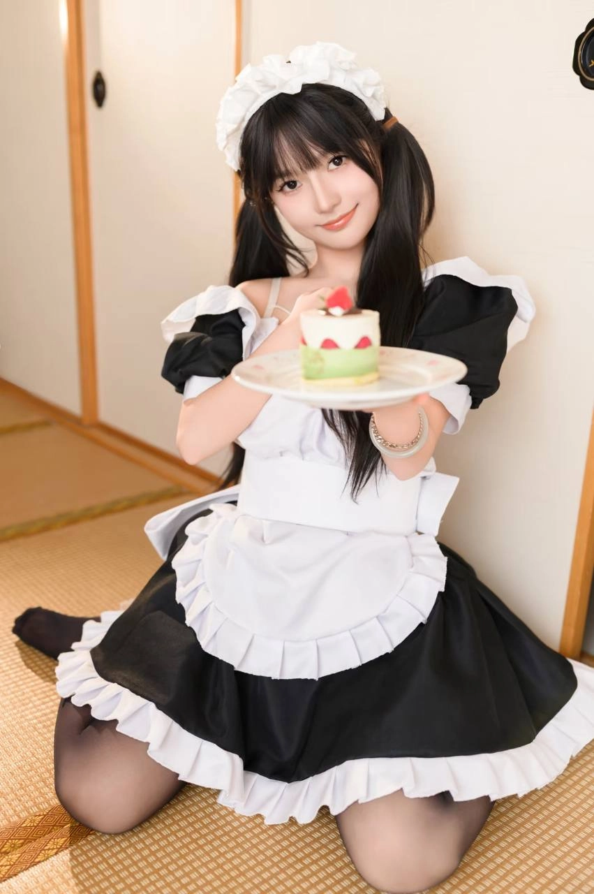 穿着女仆服的女孩吃了一块蛋糕。