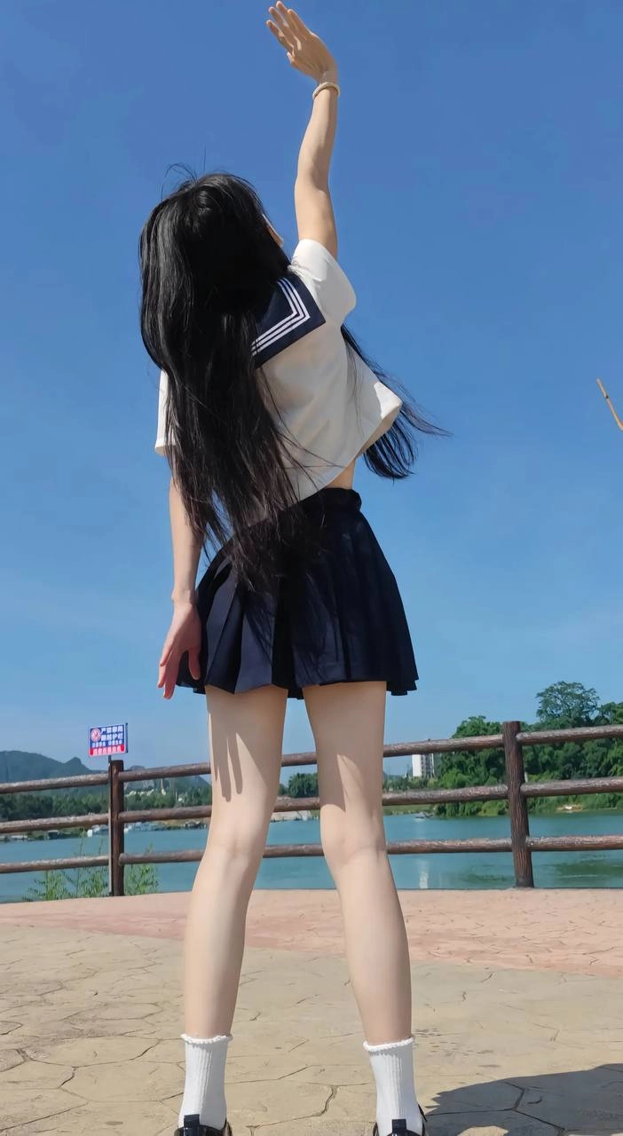 长头发和蓝色和白色衬衫的女人举起她的手臂。