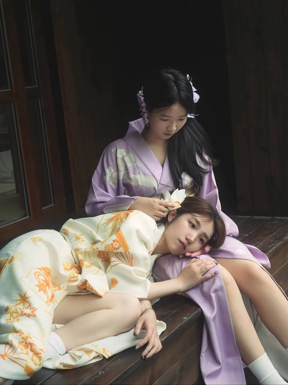 两位女士戴着吉莫诺坐在一张椅子上。