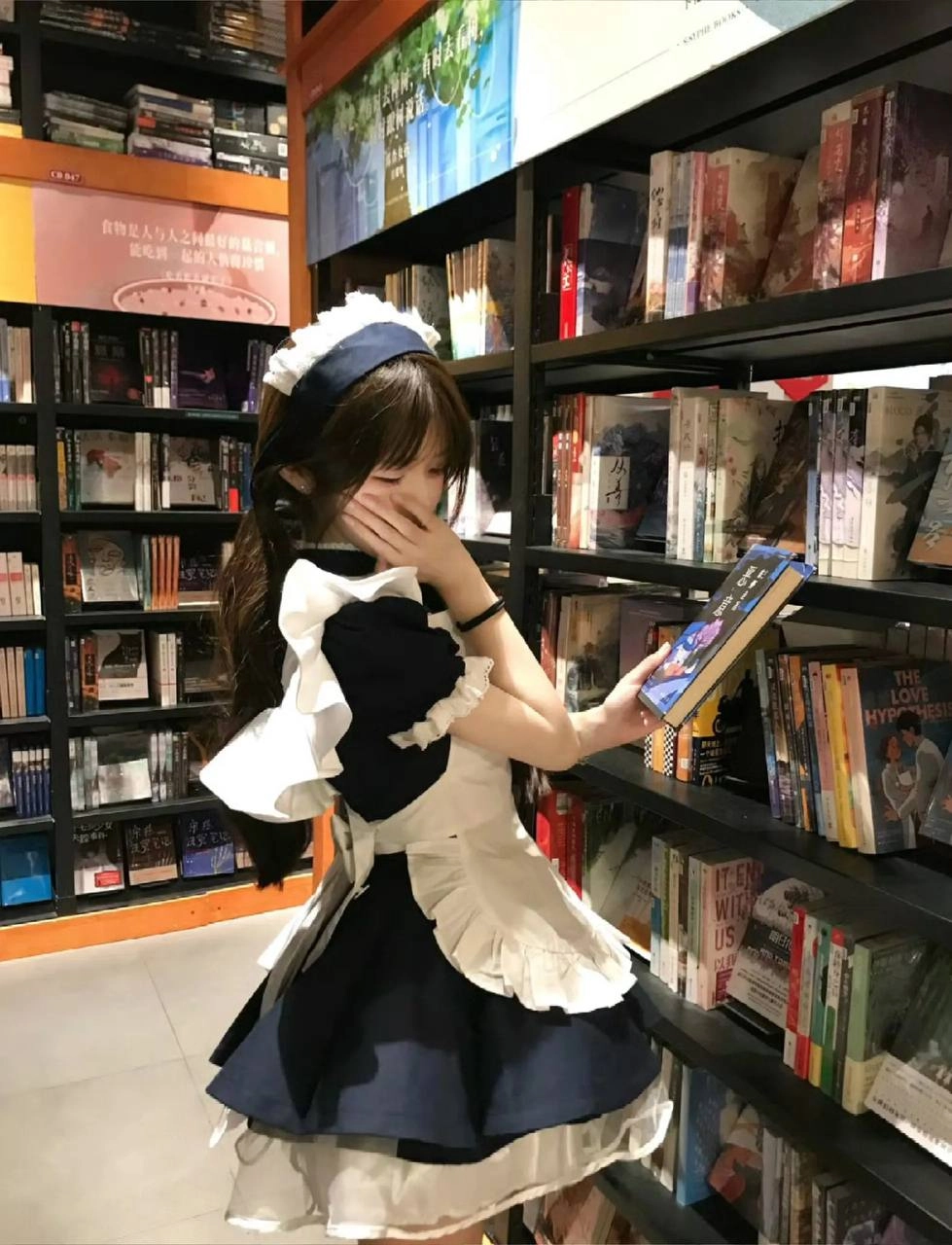 穿着女仆的服装的女人正在读一本书。