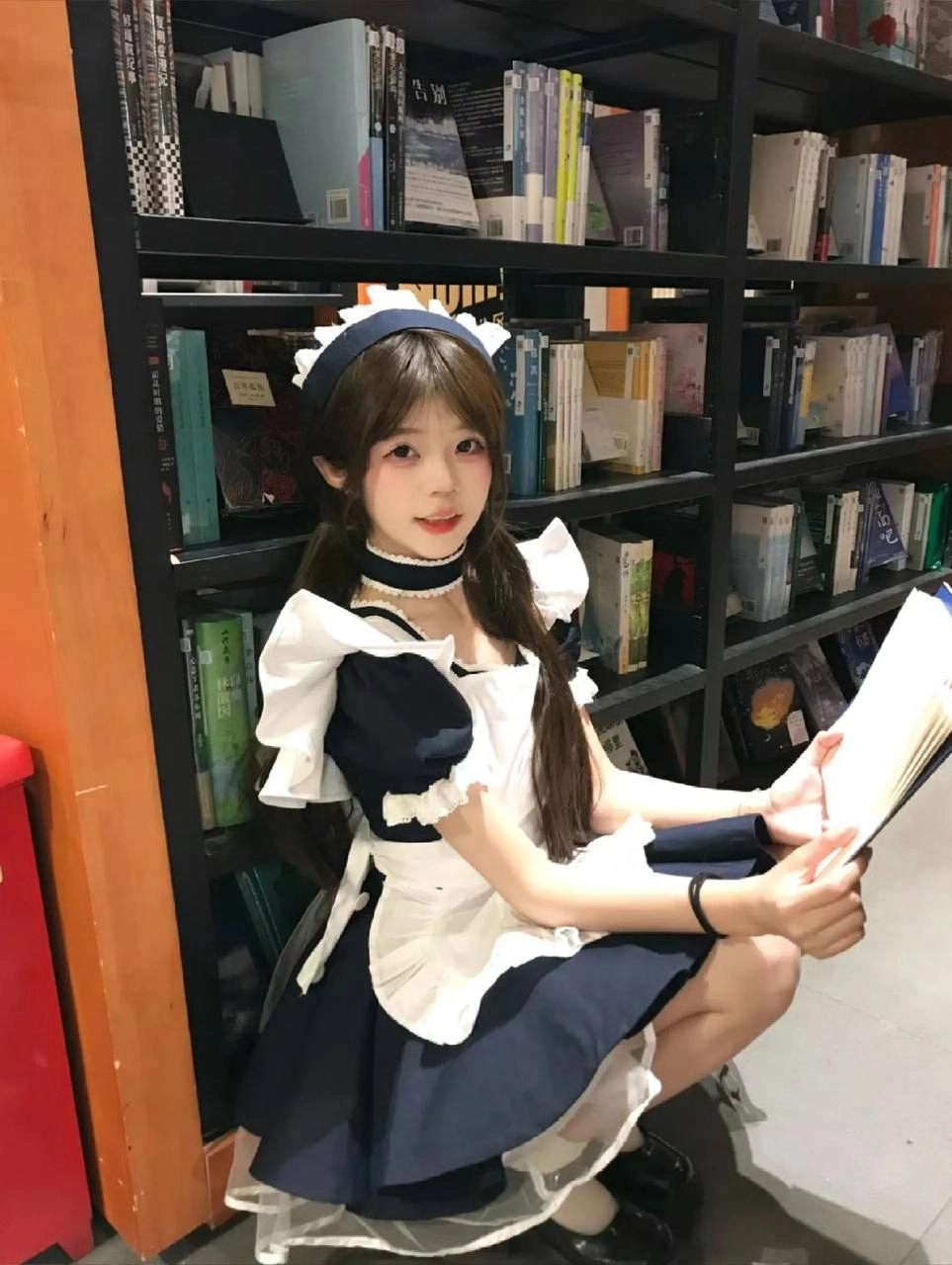 穿着女仆服的女孩正在读一本书。