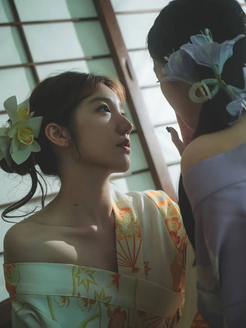 两位女士戴着吉莫诺坐在一张椅子上。