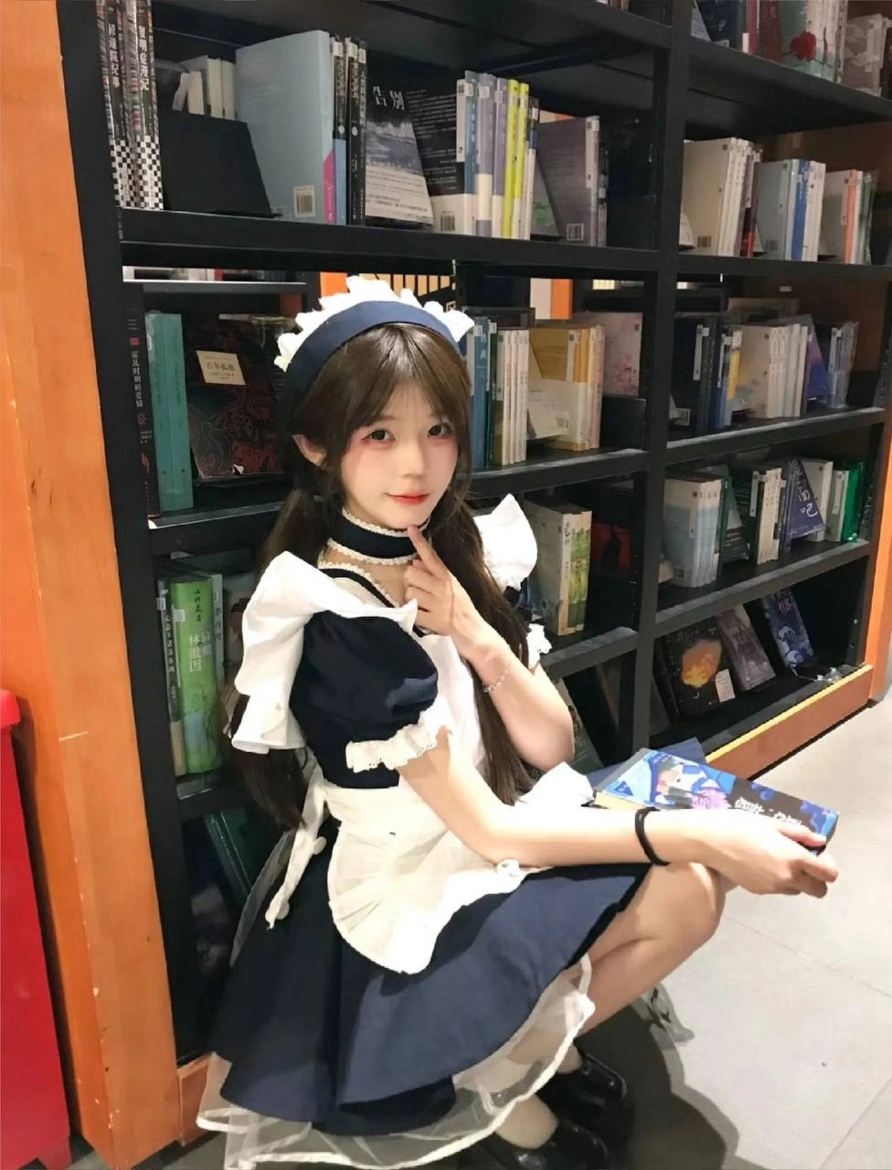 穿着女仆的服装的女人正在读一本书。