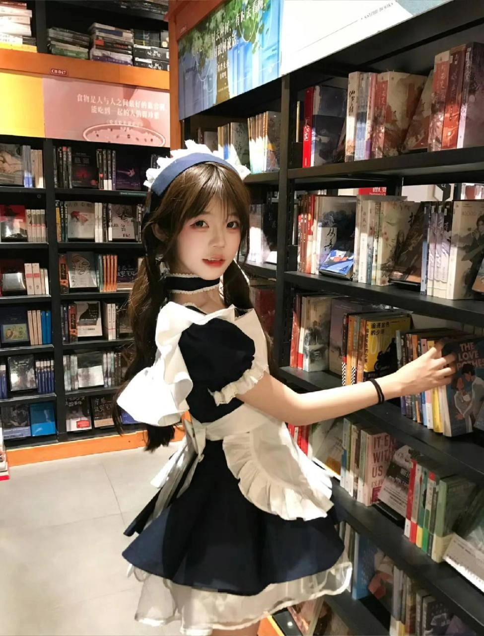 穿着女仆服的女孩正在读一本书。