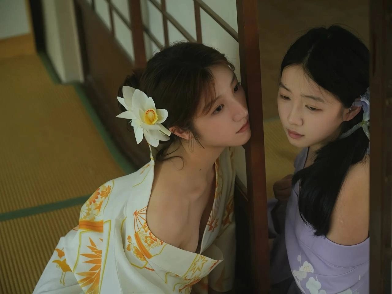 两个女孩在头发上有白色的花朵。