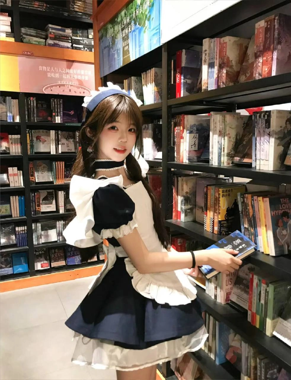 穿着女仆的服装的女人正在读一本书。