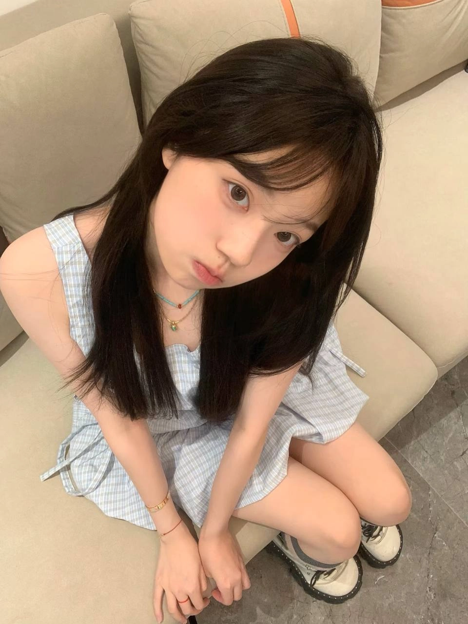 长头发的女孩和一个金色的手坐在沙发上。