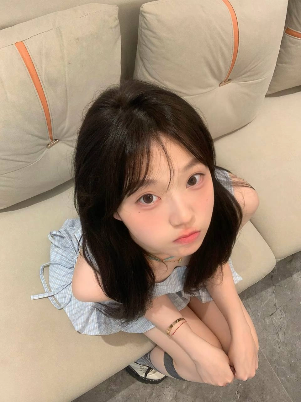 长头发的女孩和一个金色的手坐在沙发上。