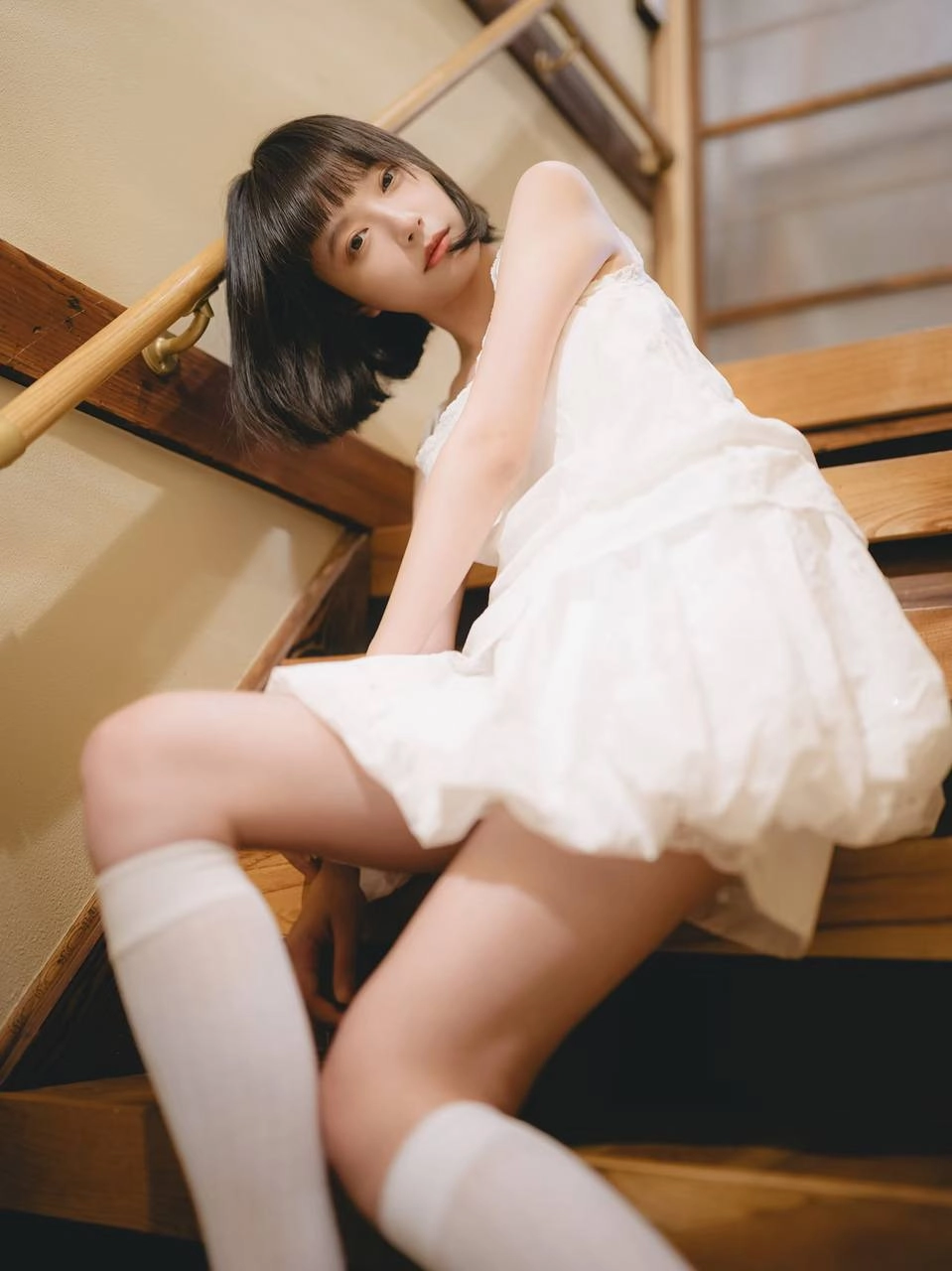 穿着白色衣服的女人坐在楼梯上。