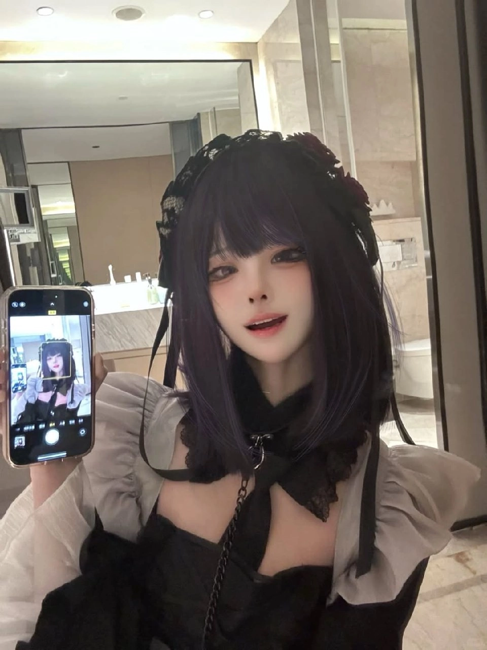 一位穿着黑色衣服的女人拿起手机拍照自己。