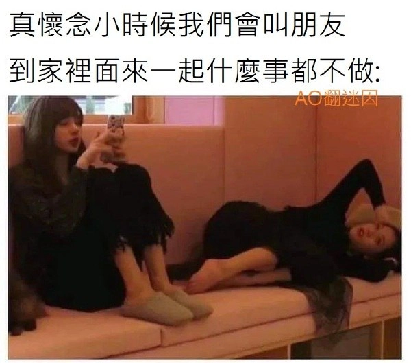 两个女人坐在沙发上,其中拿着手机。