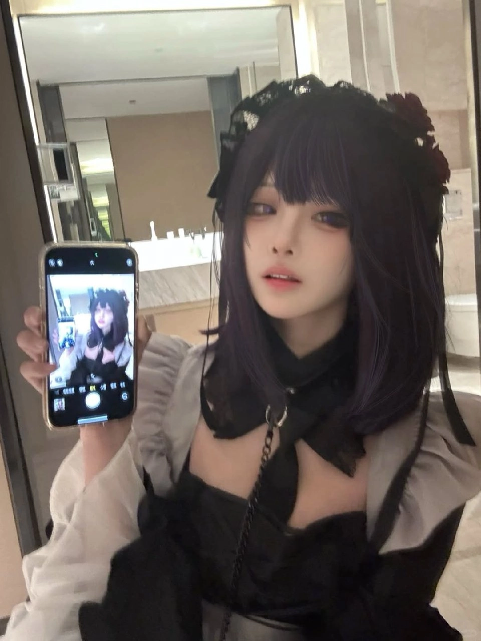 一位穿着黑色衣服的女人拿起手机拍照自己。