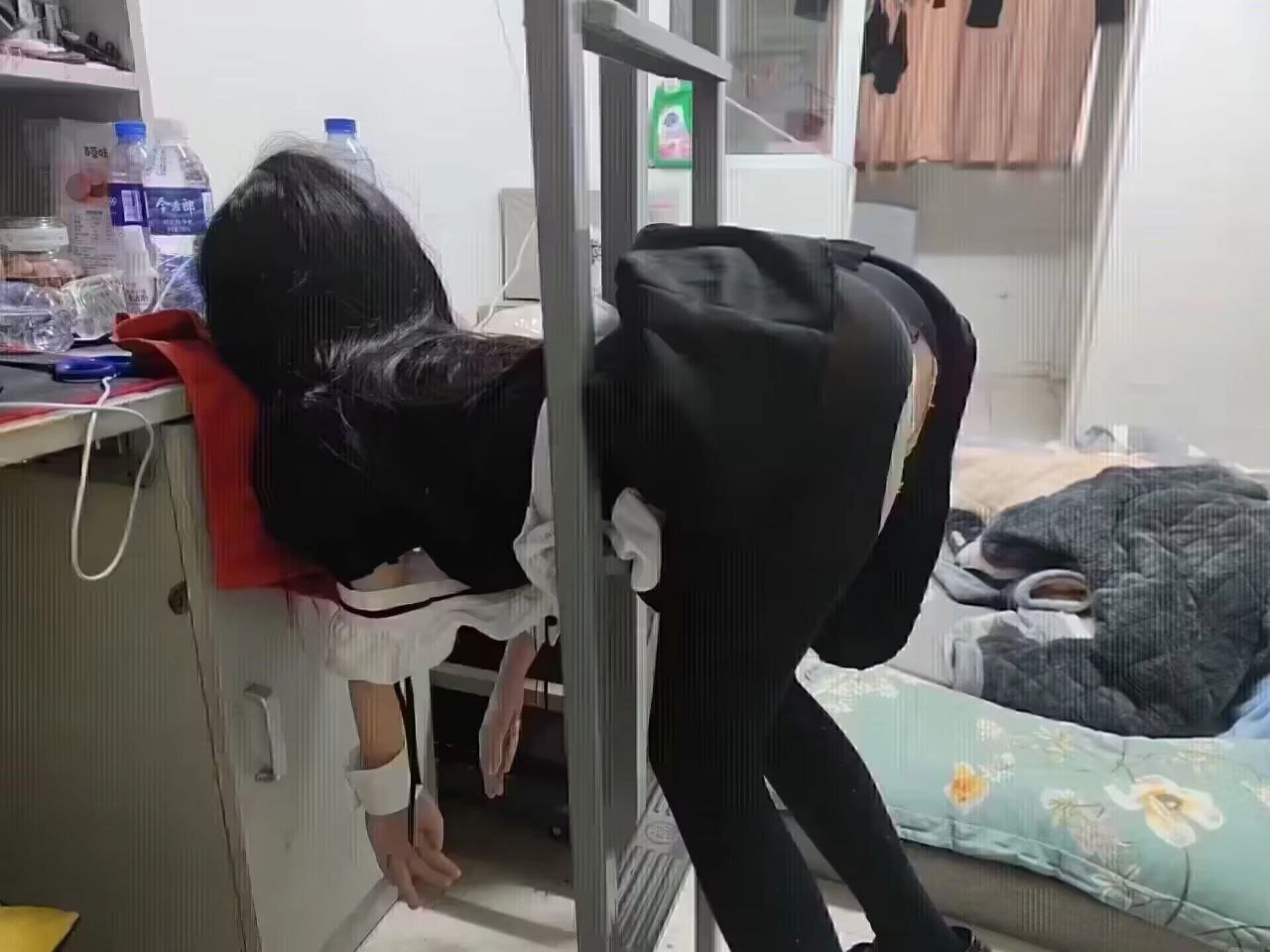 女人倾斜在一个金属极上。