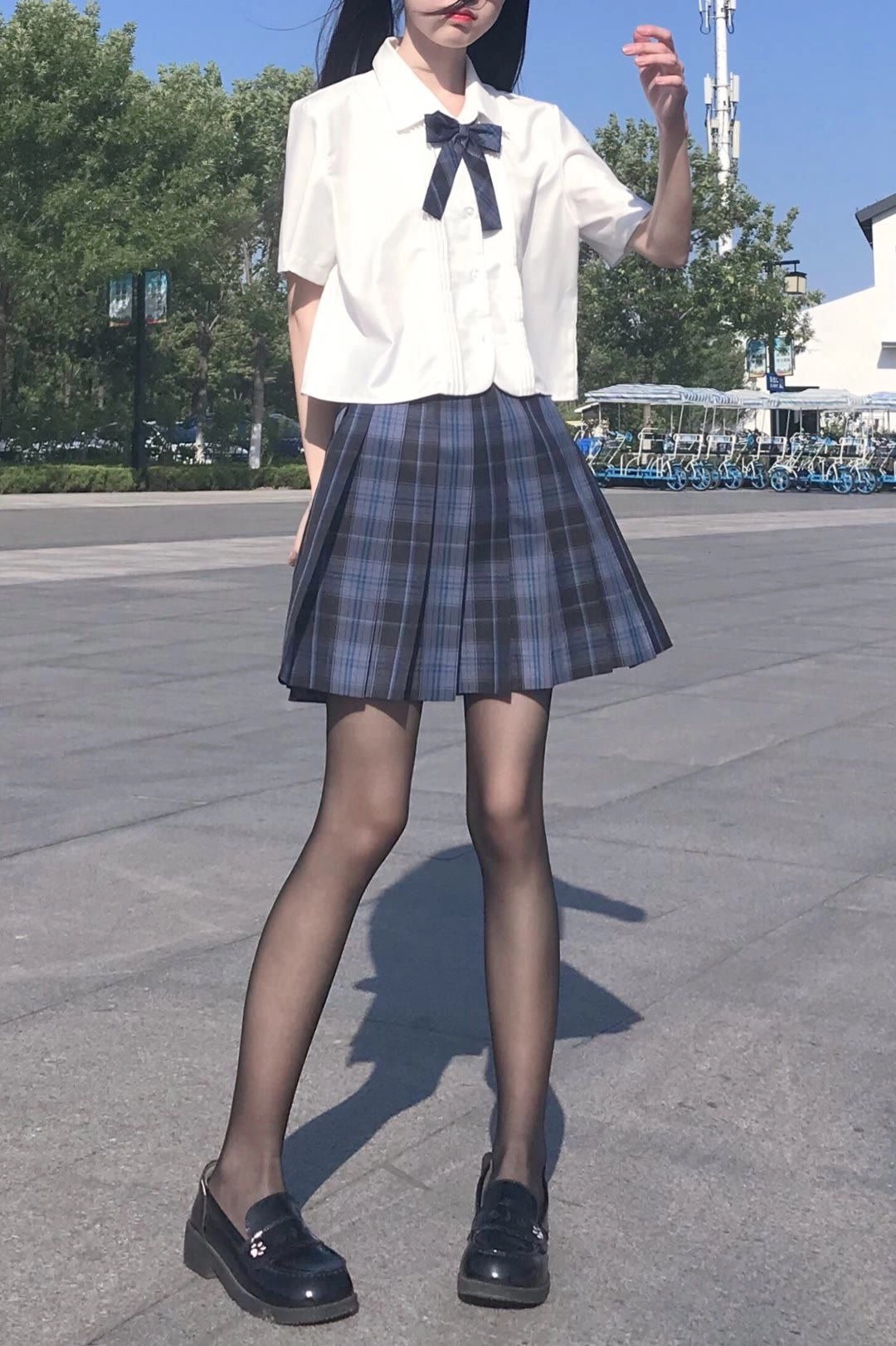 穿着黑色鞋子和黑色袜子的女人坐在椅子上。