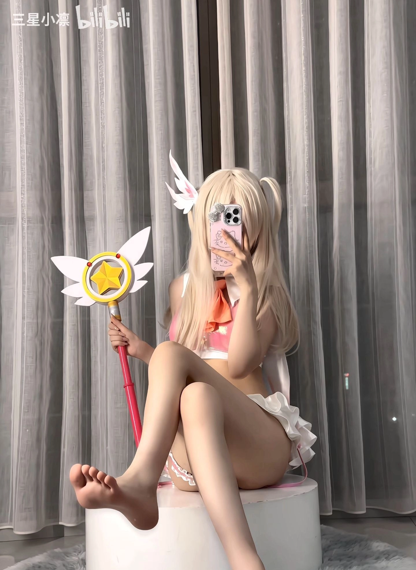 一位穿着白色裙子和粉红色星条的女人拍了一张自拍。