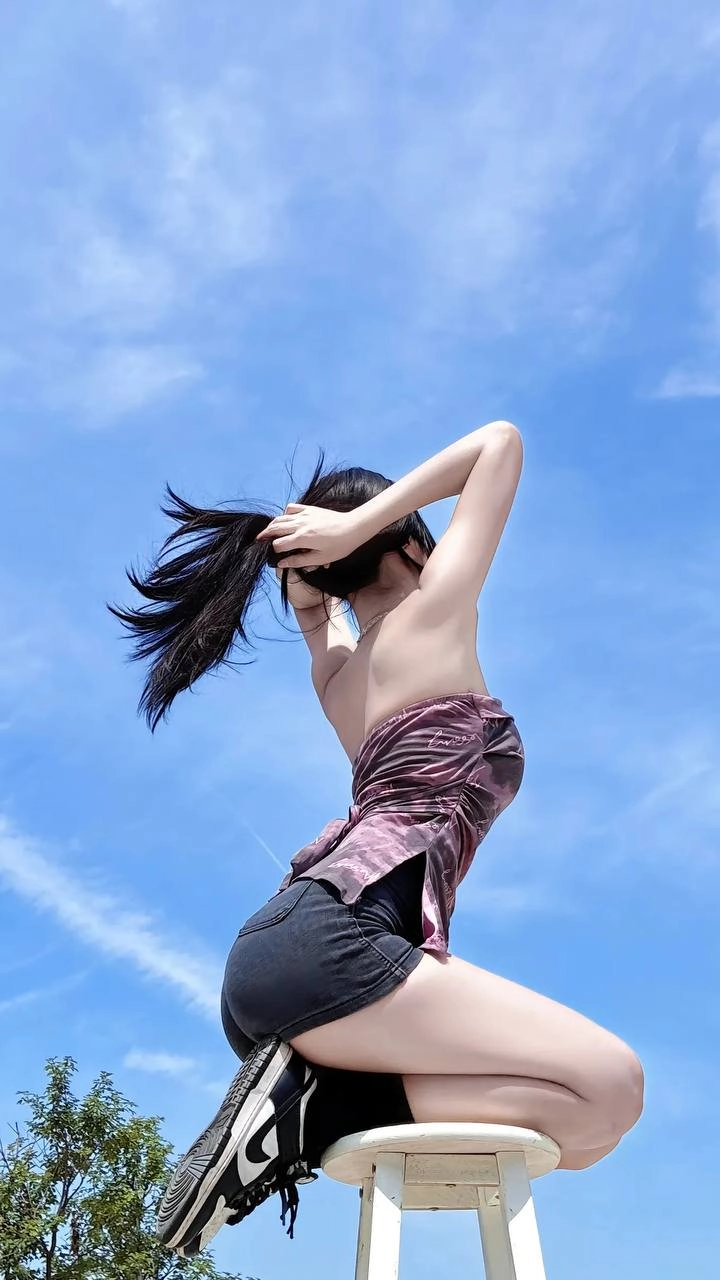 一位穿着紫色衬衫和短裤的女人正在飞翔一只子。