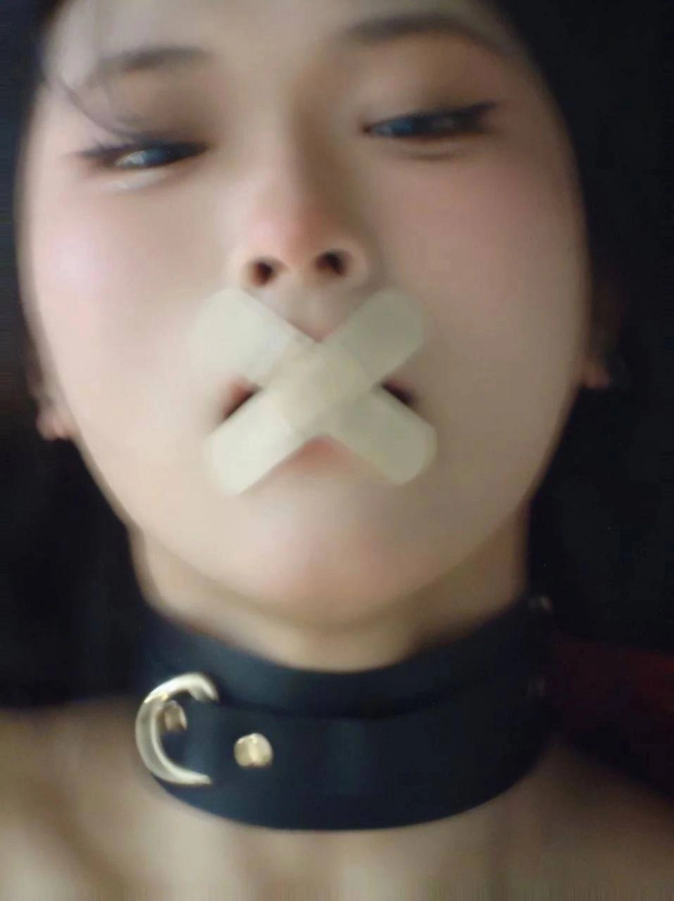 女人在她的嘴巴上有一条绷带。