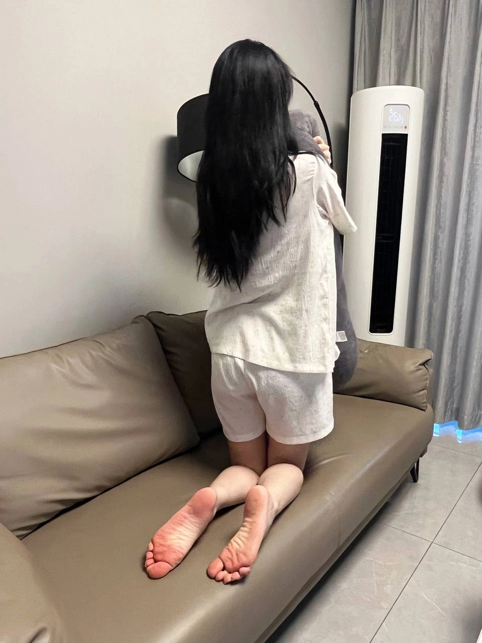 穿着白色裙子的女人坐在沙发上。