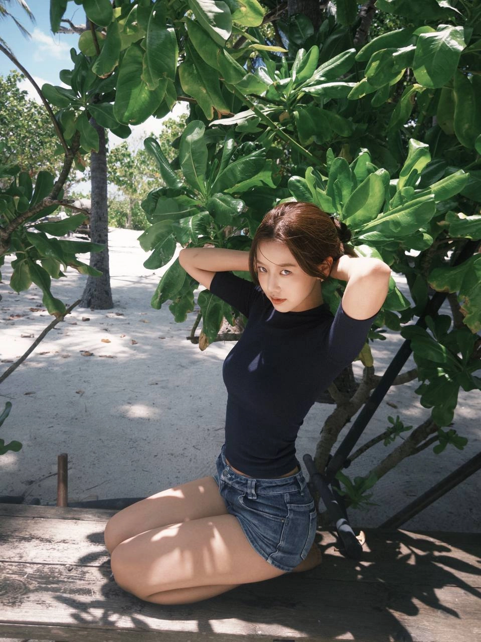 穿着蓝色衬衫和短裤的女人坐在一个凳子上。