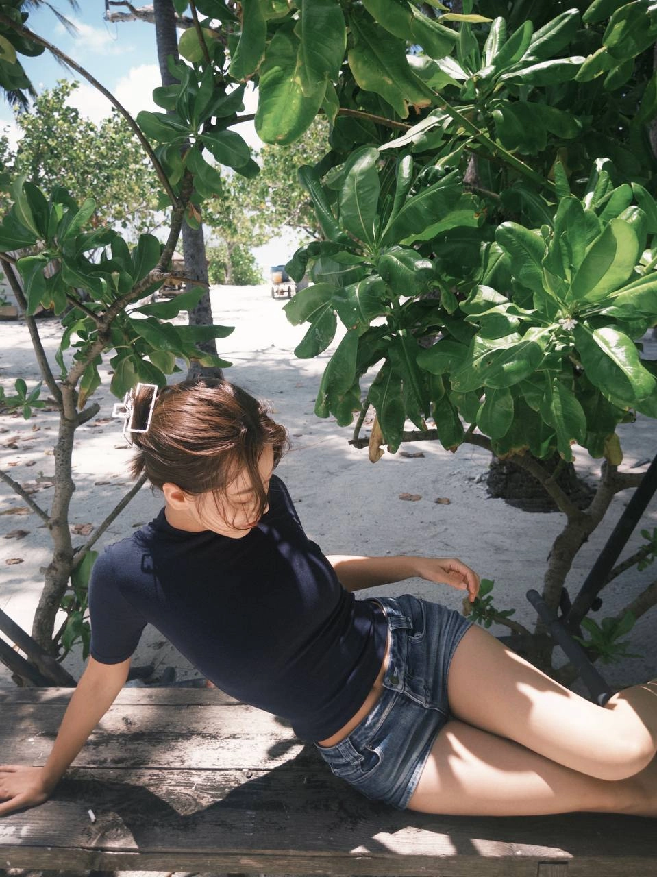 穿着蓝色衬衫和短裤的女人坐在一个凳子上。