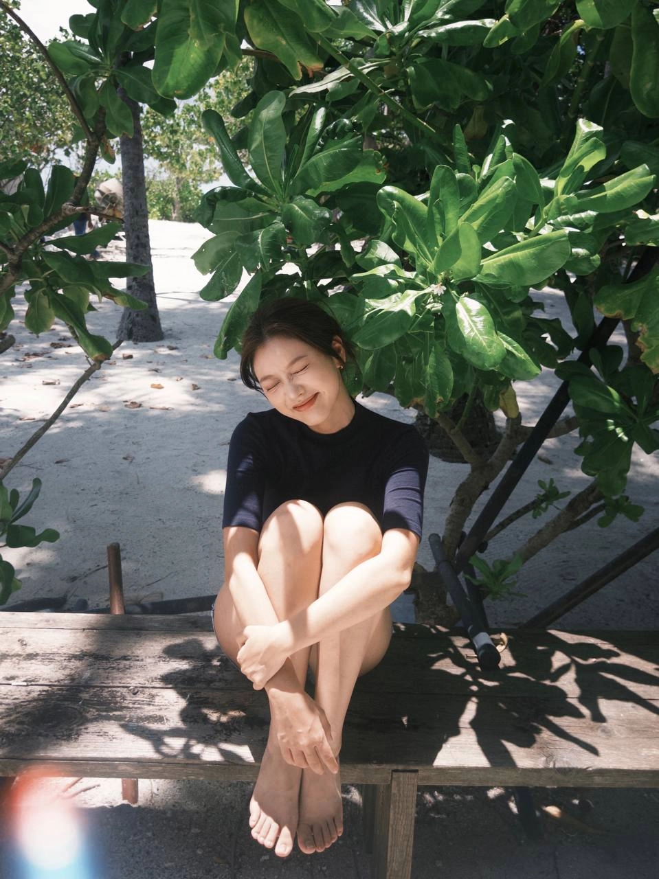 穿着蓝色衬衫和短裤的女人坐在一个凳子上。