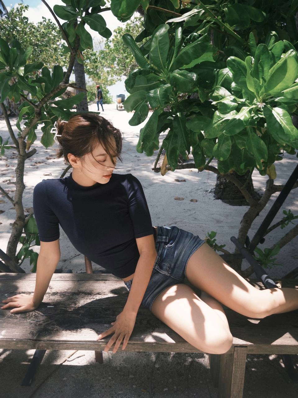 穿着蓝色衬衫和短裤的女人坐在一个凳子上。