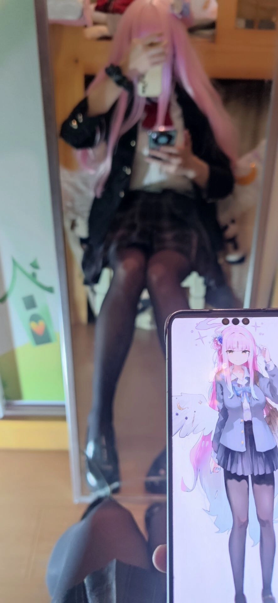 人坐在那里,拿着一台手机,上面有一位卡通人物。