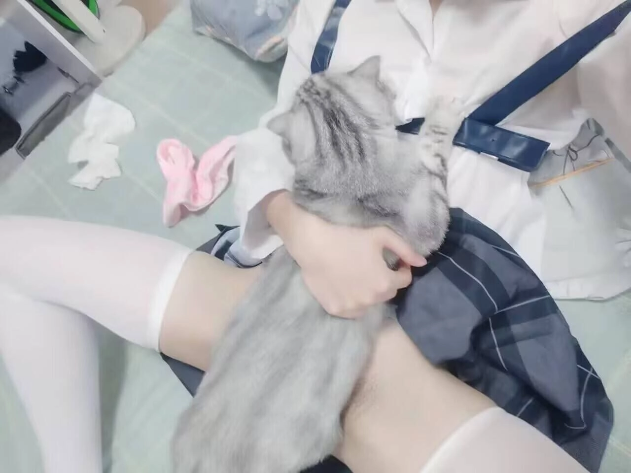 女人抱着一只猫在她的膝盖上。