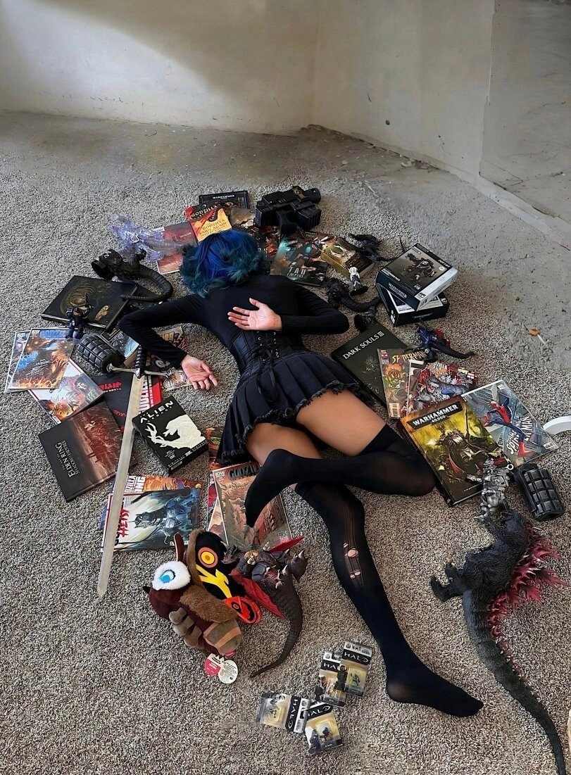 女人躺在地板上,被书籍和玩具包围。