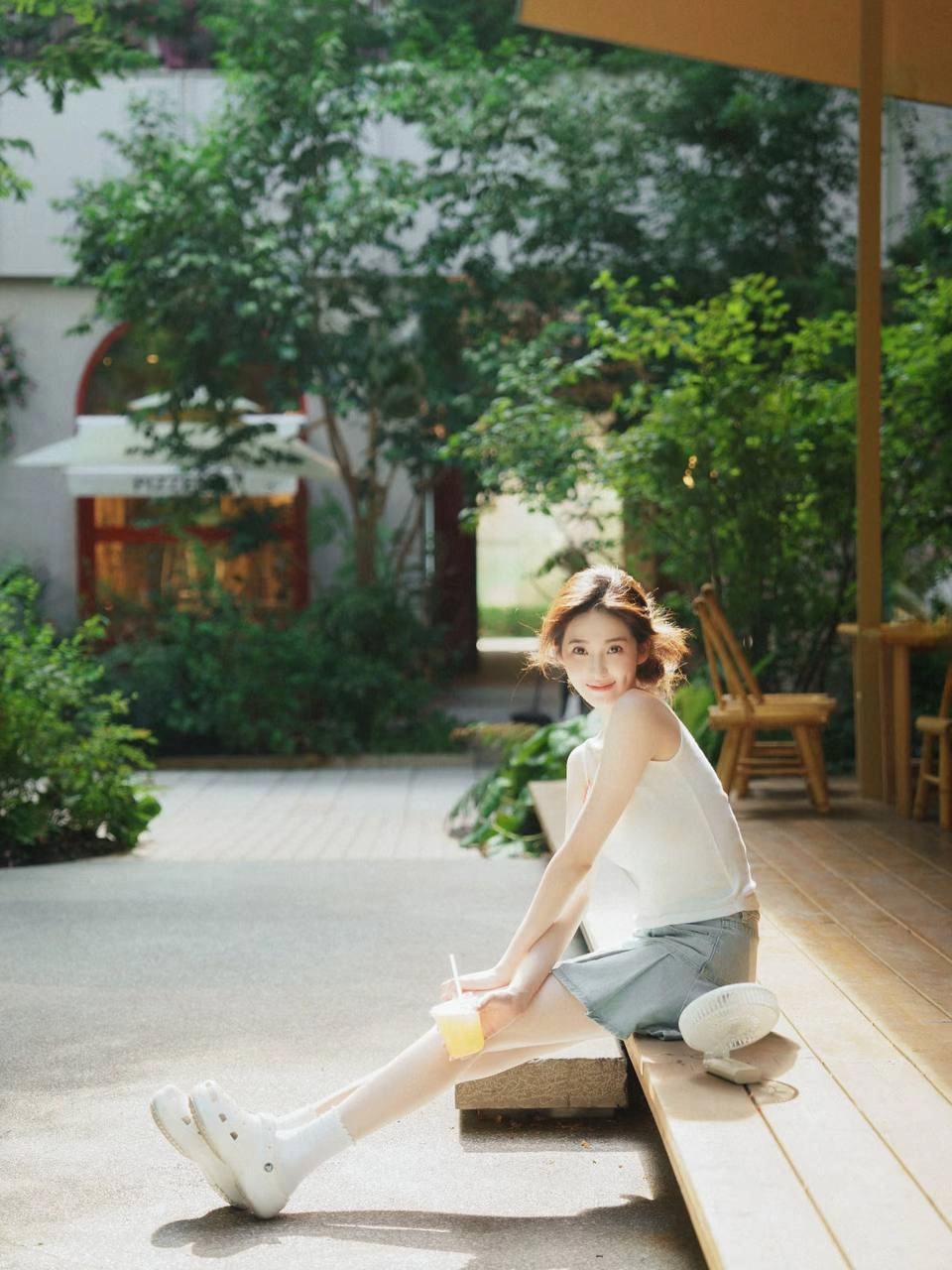 女人坐在椅子上,手里拿着一杯酒。