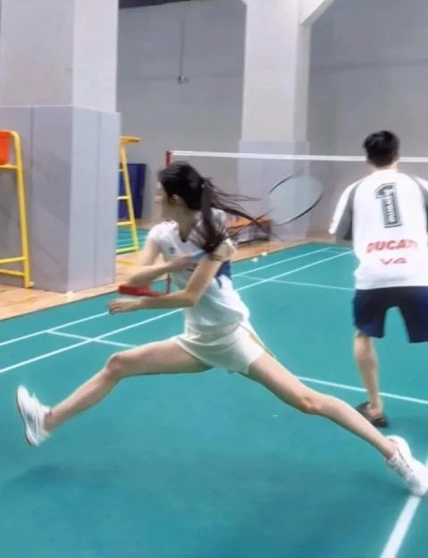 女人在打网球,摇滚她的摇篮。